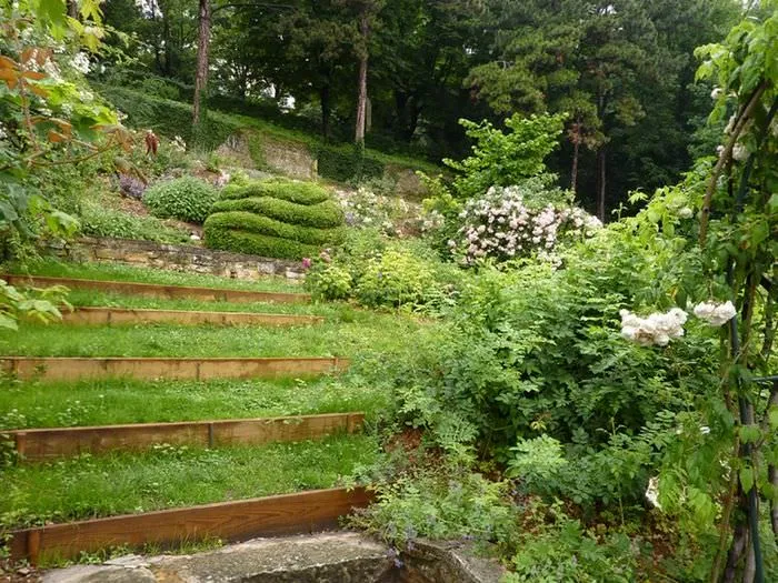 Склон садового участка с деревянными террасами