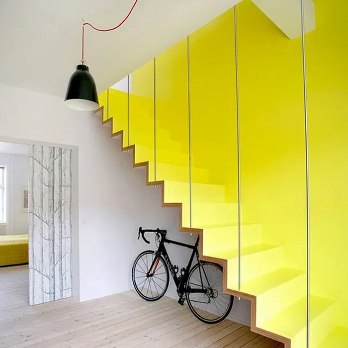 Лестница лимонного цвета, которая сливается с контрастной стеной того же оттенка.