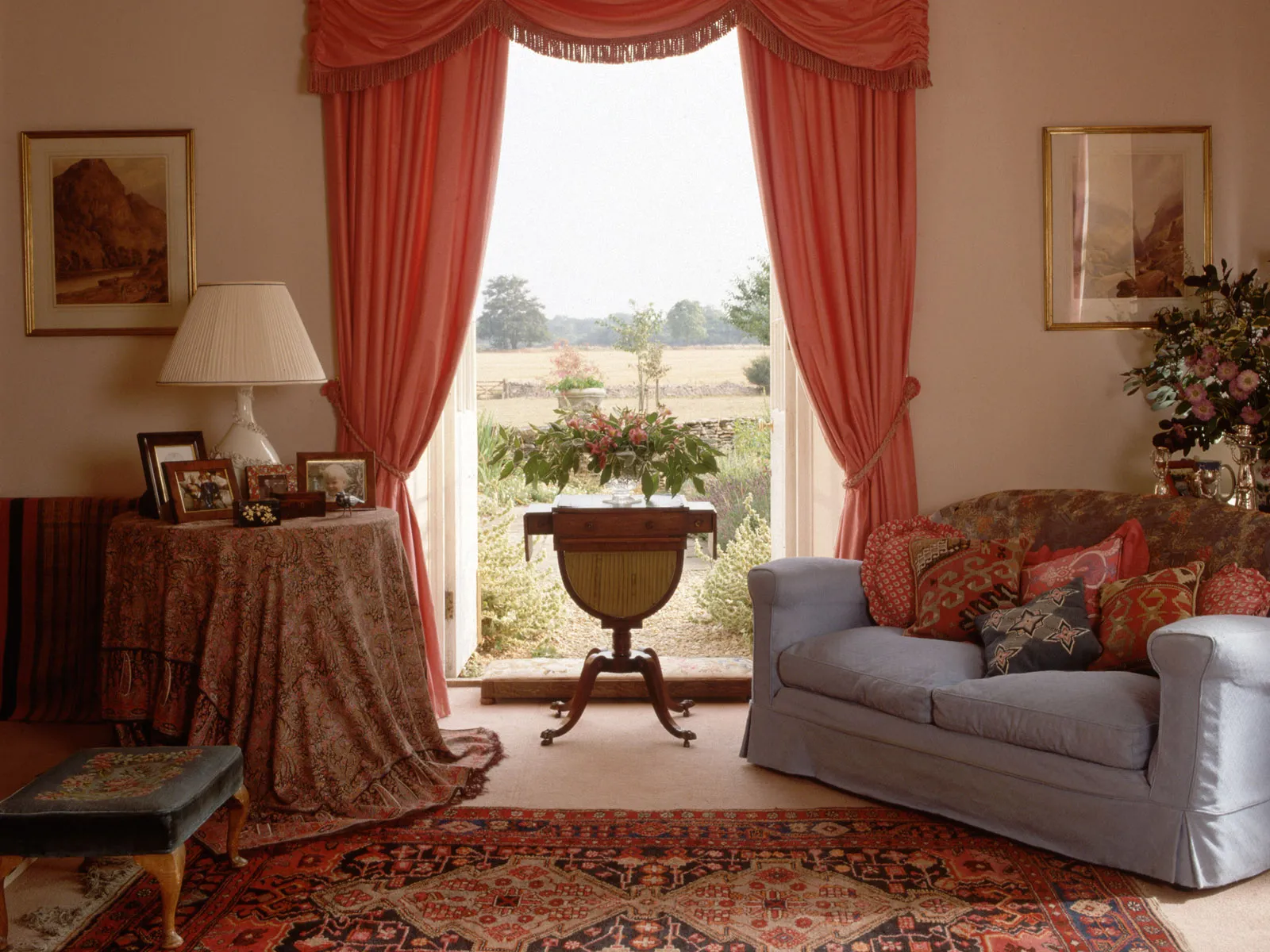 Red curtains frame a window in a country style living room.