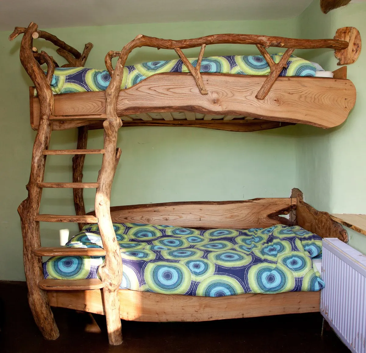 Двухъярусная самодельная кровать может в точности повторять фабричные модификации, а может выглядеть неординарно, как это показано на фото