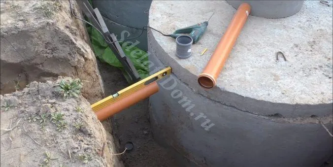 Укладываем канализационные трубы в траншее под уклоном