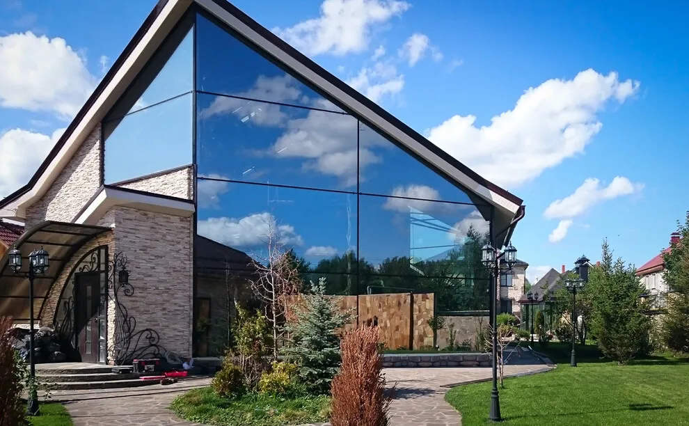 Отделка фасада дома стеклопанелями с отражающей поверхностью