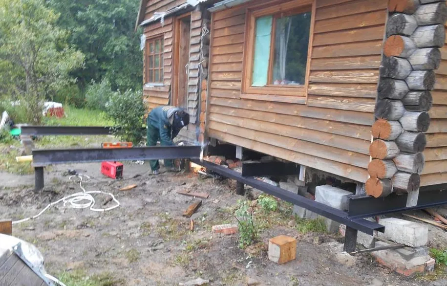 Замена сгнивших венцов деревянного дома с помощью рамки из швеллеров