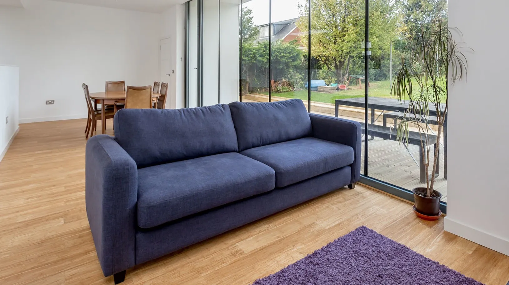 Синий однотонный диван можно использовать в качестве акцента в гостиной